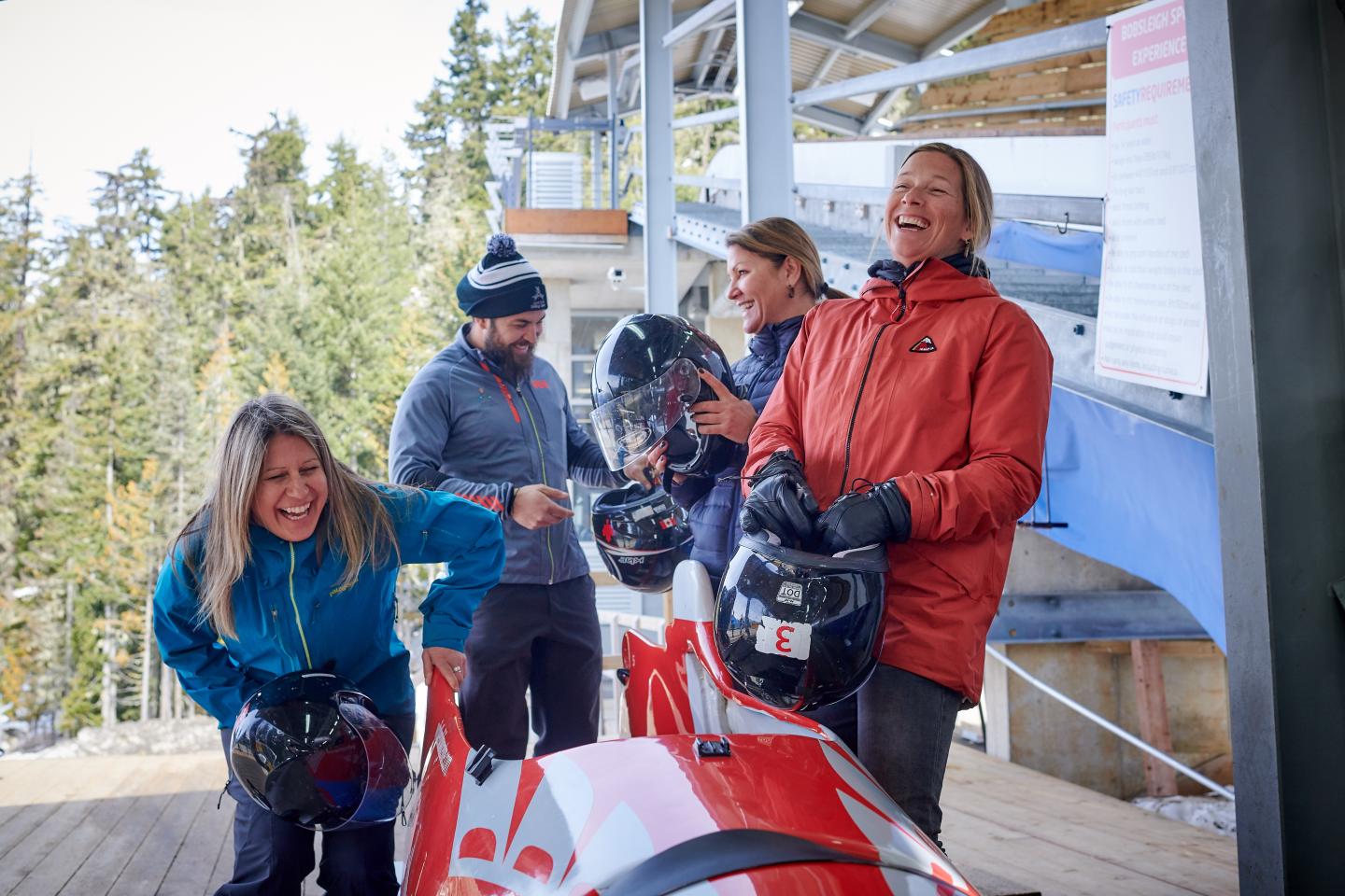 people laughing while preparing for boblsed ride