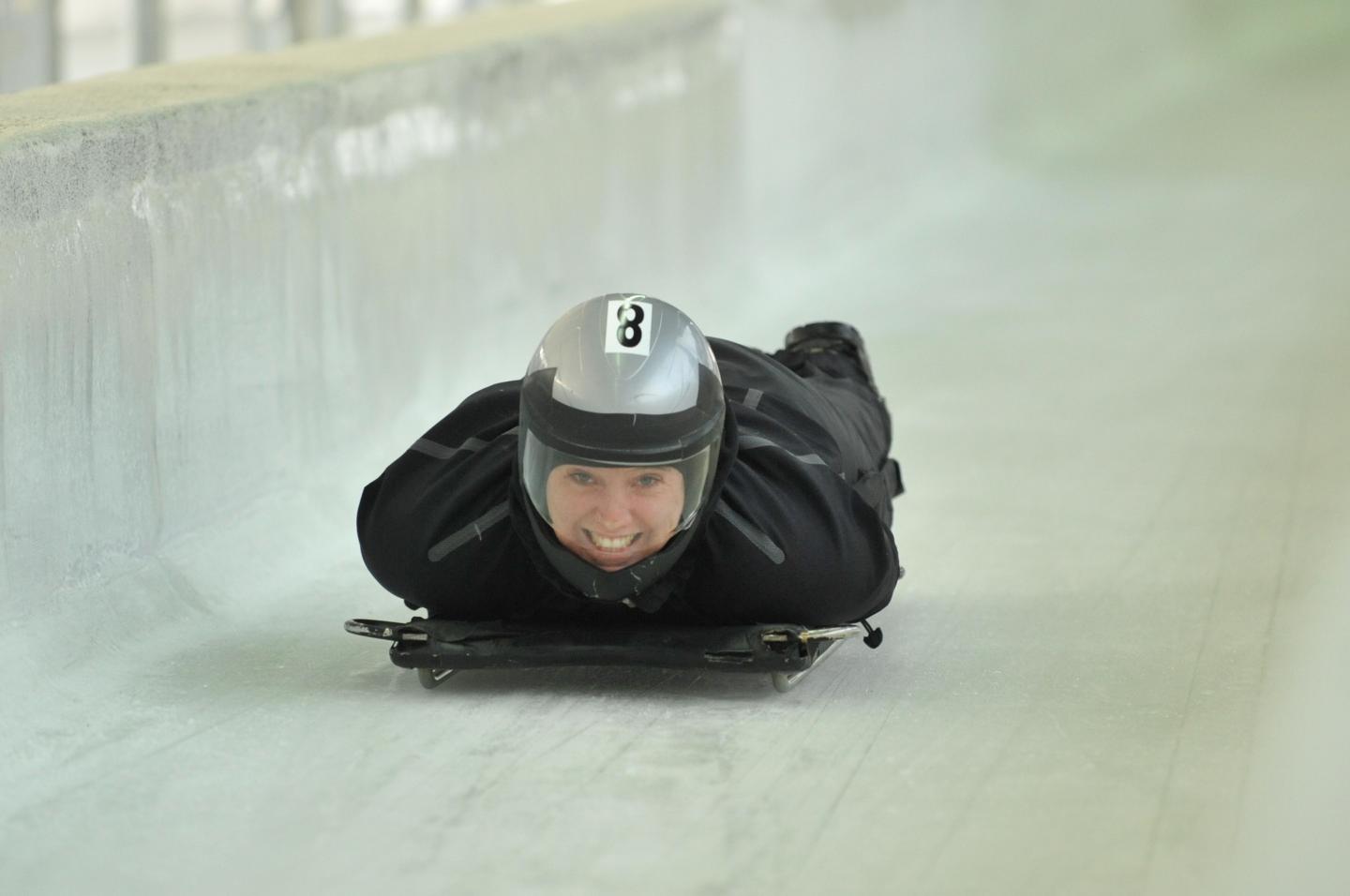 person smiling while on skeleton track