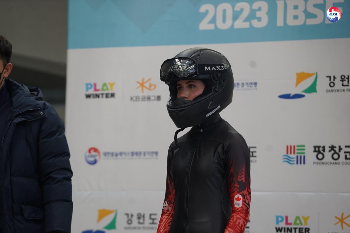 athlete wearing helmet in front of press screen