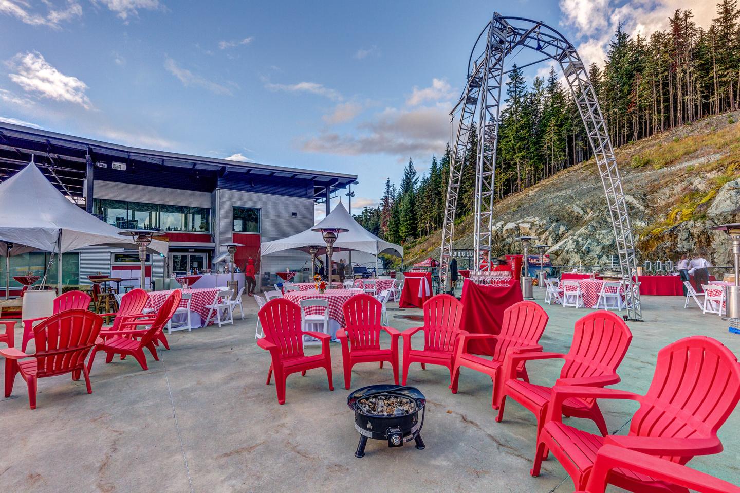 chairs setup around fire pits at outdoor venue in the mountains