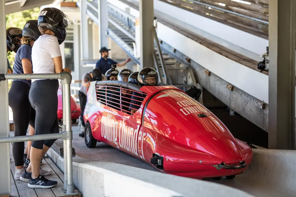 Bobsled team in red sled preparing for a run.